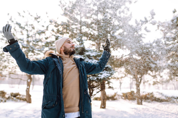 Handsome bearded young  man standing outdoors fur hood in winter season forest. Season holiday leisure. Nature. - Foto, immagini