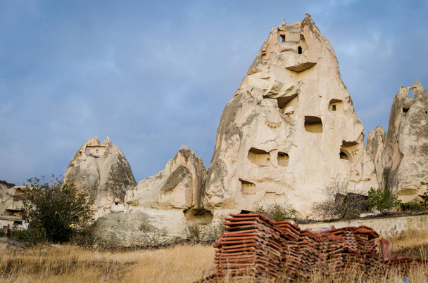 Widok na częściowo zawalone naturalne formacje skalne i sztuczne jaskinie, gołębie wewnątrz niego znane jako bajkowe kominy, położone w miejscowości Goreme, region Kapadocja w Turcji - Zdjęcie, obraz
