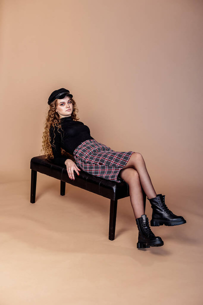 Attractive woman with long curly hair wearing a skirt, and black leather shoes. New collection of women's spring shoes - Fotó, kép