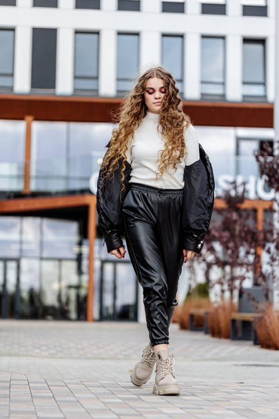 Beautiful stylish woman posing in fashionable clothes in leather shoes. Casual style. Urban fashion style. New collection of spring women's shoes - Foto, imagen