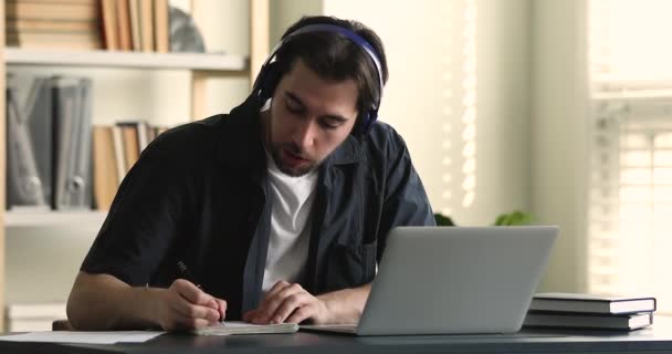 Guy wear headphones studying listens online tutor or audio course - Imágenes, Vídeo