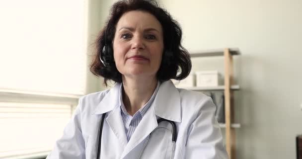 Older woman doctor talk to patient through videoconference, webcam view - Felvétel, videó