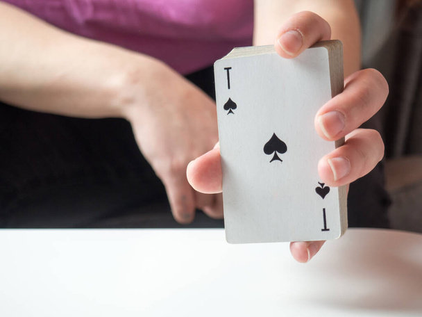 a deck of playing cards in a girl's hand with an ace of spades - Foto, Bild