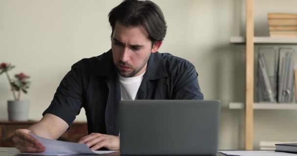 Perplexed employee sit at desk do paperwork, faced with problem - Materiał filmowy, wideo