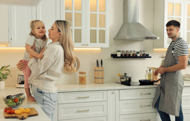Happy family spending time together while cooking in kitchen - Photo, image