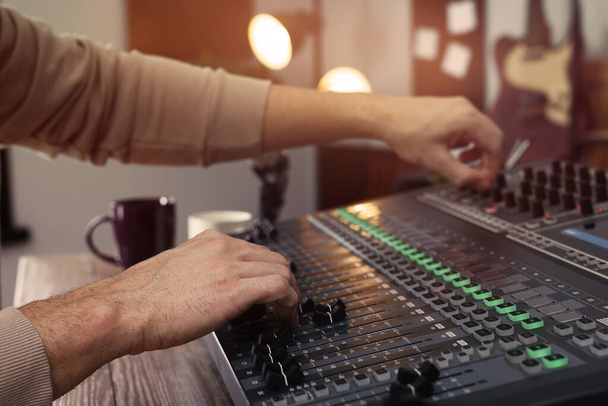 Man working with professional mixing console in modern radio studio, closeup - Фото, изображение