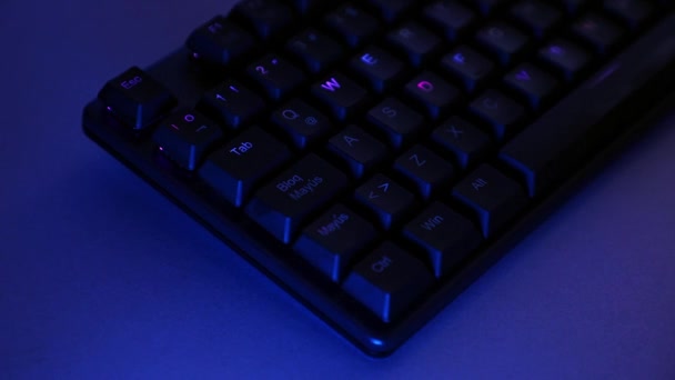 Panorama mecánico del teclado con iluminación RGB en un escritorio - Metraje, vídeo