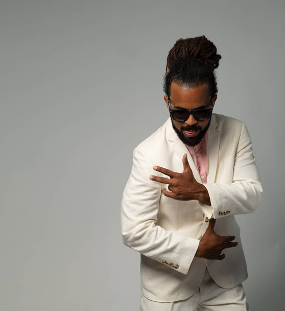 afro cuban with dreadlocks in suit thinking with sun glasses dancing isolated - Fotografie, Obrázek