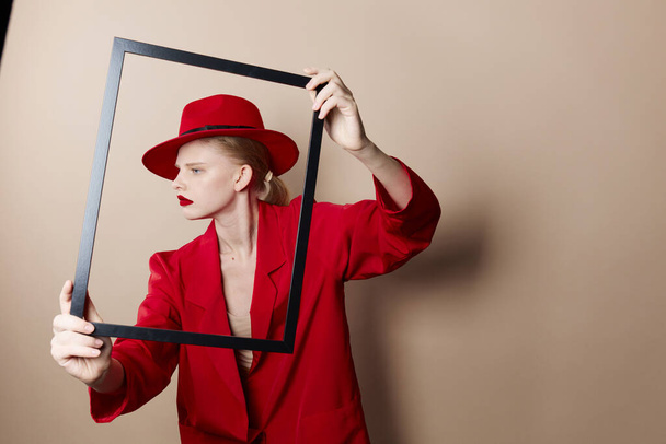 mujer glamorosa marco en la mano en sombrero rojo y chaqueta estilo de vida posando - Foto, imagen