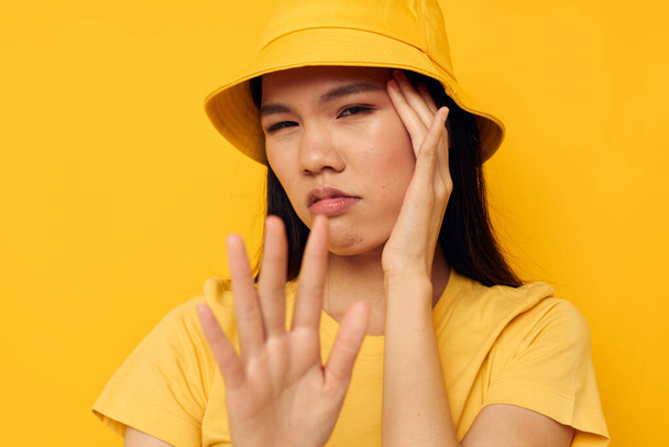 pretty brunette wearing a yellow hat posing emotions yellow background unaltered - Fotoğraf, Görsel