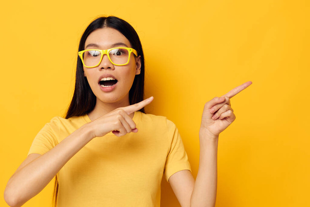 woman in yellow t-shirts with glasses posing fashion yellow background unaltered - Φωτογραφία, εικόνα