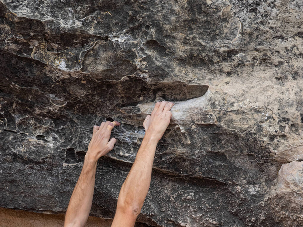 Handen en vingers verbonden met witte magnesia van een jonge klimmer in een natuurlijke omgeving. Concept bouldering. - Foto, afbeelding
