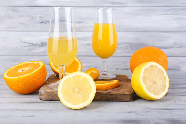 glasses of juice with fresh fruits on grey wooden table - Foto, Bild