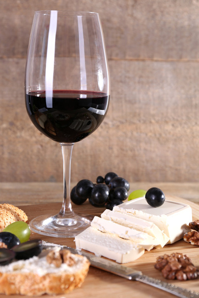 beautiful still life with wine, cheese and ripe grape on wooden background - Foto, Imagem