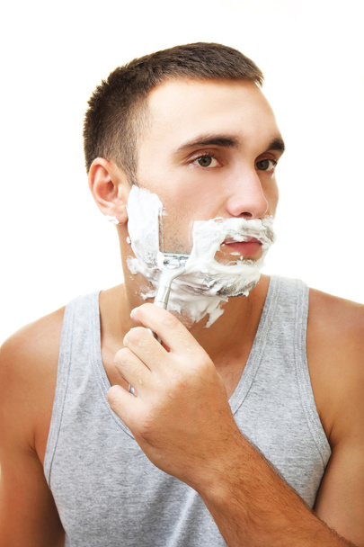 Young man shaving his beard in bathroom - Foto, Imagem