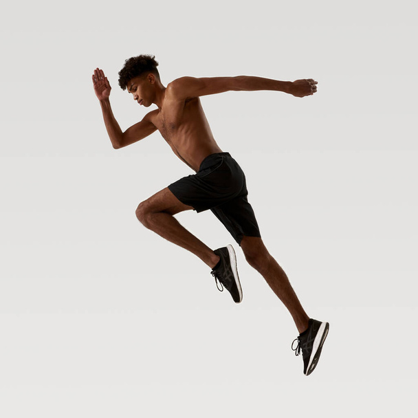 Side view of black serious sportsman running - Photo, image