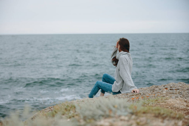 ładna kobieta swetry zachmurzone morze podziwiając przyrodę Koncepcja relaksu - Zdjęcie, obraz