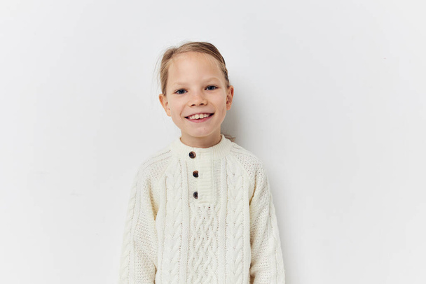 little girl white sweater hand gestures light background - Foto, immagini