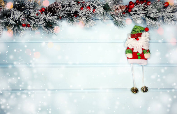 karácsonyi Santa játék téli ágak kúpok és hó, kék fából készült textúra                               - Fotó, kép