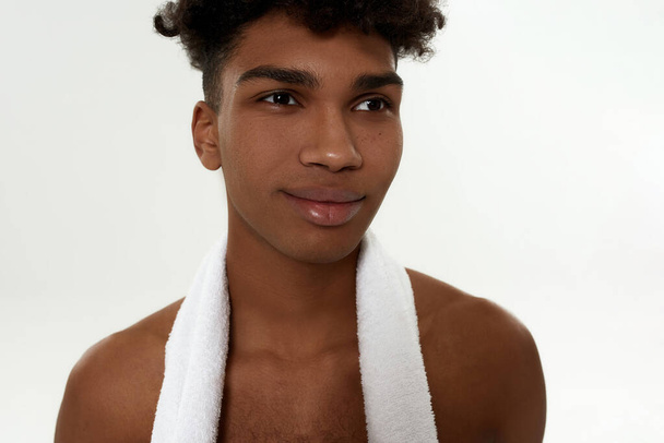 Black curly sportsman with towel looking away - Фото, изображение