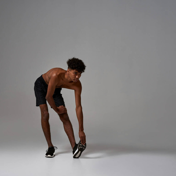 Black sports man stretching and looking away - Φωτογραφία, εικόνα