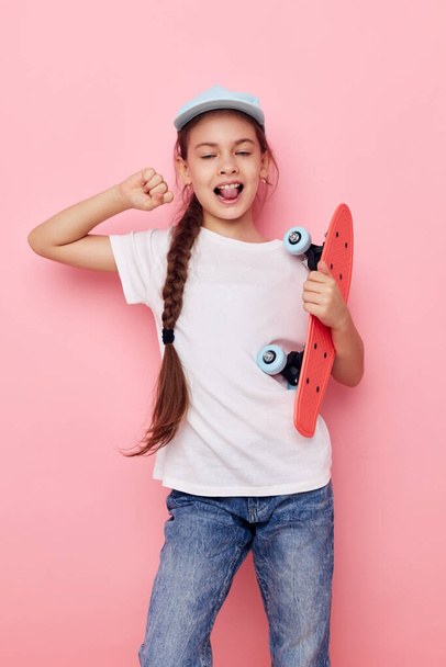 little girl cap in white t-shirt skateboard isolated background - 写真・画像