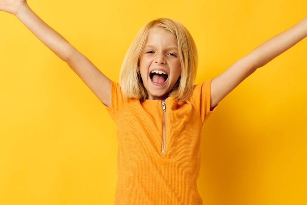 cute little girl in a yellow t-shirt smile posing studio color background unaltered - Zdjęcie, obraz