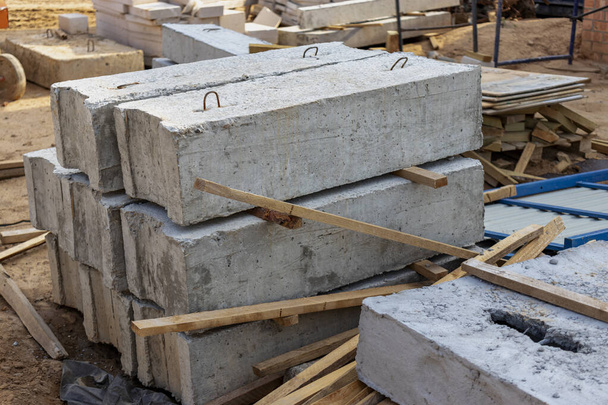 Versterkte betonnen platen en bouwmaterialen op de bouwplaats. Opslag van materialen voor de bouw van een huis. Industriële engineering - Foto, afbeelding