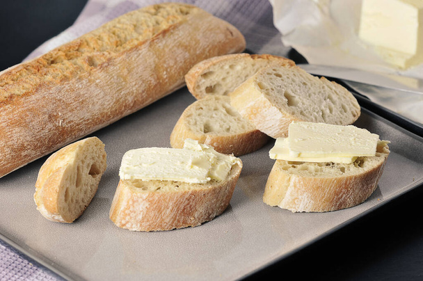 butter, knife and sliced baguette - Photo, Image