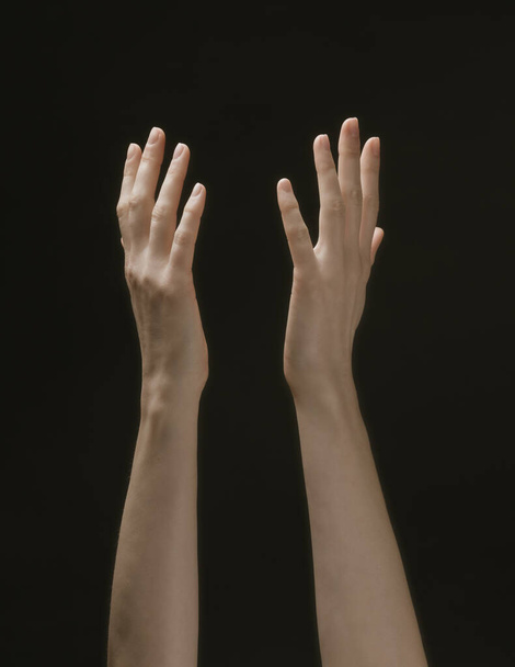 Praying hands to God in the dark. Woman hands reaching out to God or for help in barokko style - Фото, изображение