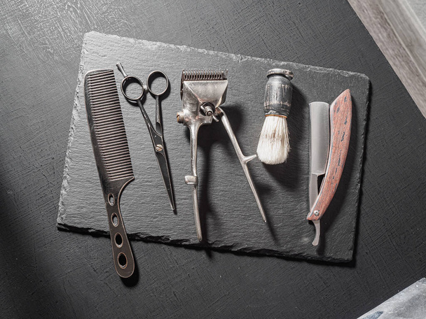 vintage κουρευτικά εργαλεία επικίνδυνο ψαλίδι κομμωτικής παλιά χειροκίνητη χτένα ξυρίσματος βούρτσα. σε μαύρο - Φωτογραφία, εικόνα