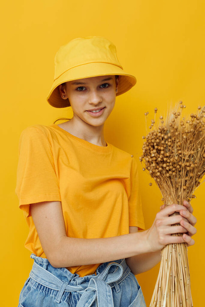 молодая женщина букет сушеных цветов в руках Молодежный стиль повседневной одежды в шляпе - Фото, изображение