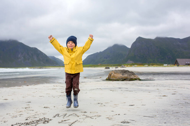 Cute child, running on norwegian white sand beach in the summer, Lofoten, Norway - Zdjęcie, obraz