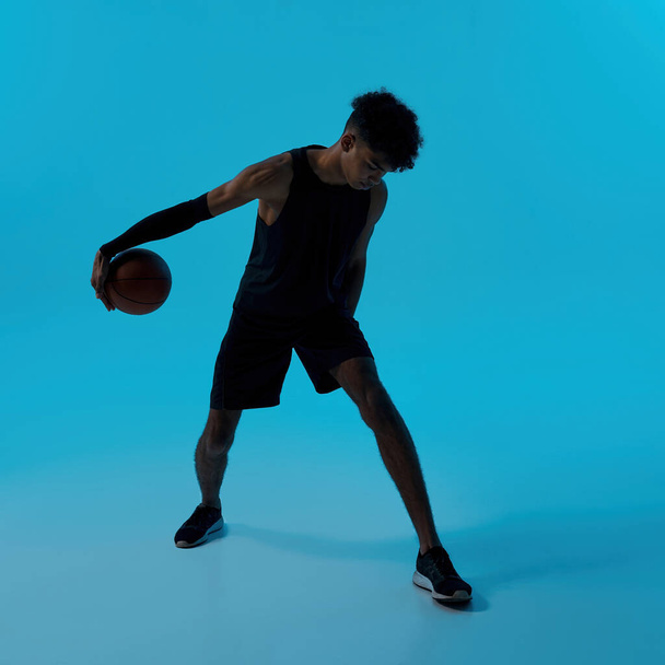 Black male player dribbling with basketball ball - 写真・画像