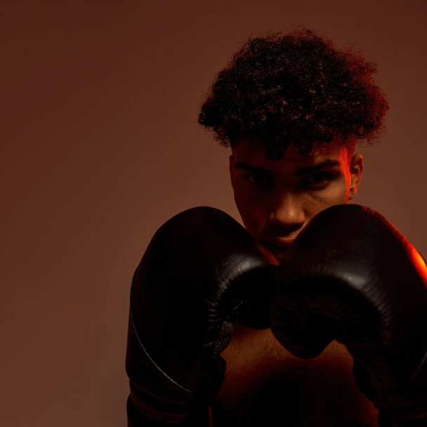 Black male boxer in boxing gloves look at camera - Zdjęcie, obraz