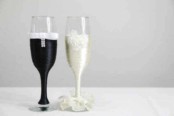 Two glasses decorated as if they were the bride and groom, a gift that symbolizes their love and is for home decoration - Zdjęcie, obraz