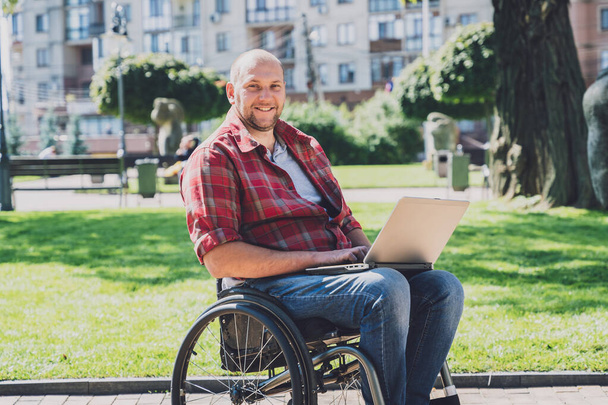 Freelancer with a physical disability who uses wheelchair working at the park - Photo, Image