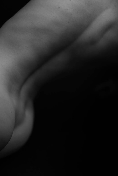 Athletic nude woman body on dark background. Fine-art photo of nude woman body. - Fotografie, Obrázek