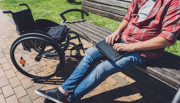 Freelancer with a physical disability who uses wheelchair working at the park - Foto, imagen