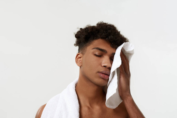 Black tired sportsman wiping face with towel - Zdjęcie, obraz