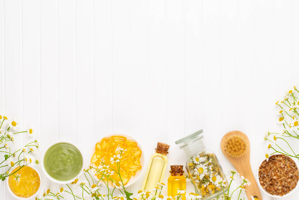 Composition homemade cosmetic, aromatherapy with natural cosmetics and chamomile flowers on light background. - Foto, afbeelding