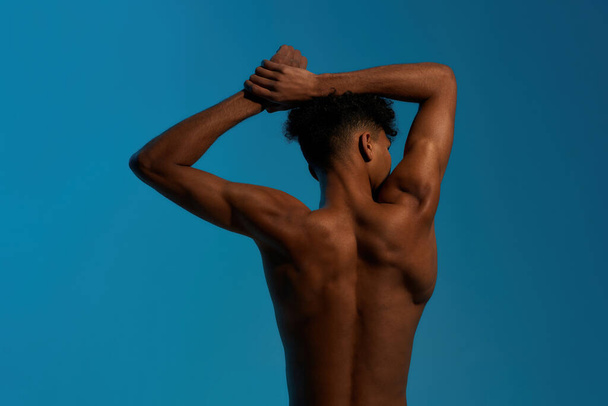 Back of black sportsman warming up before training - Фото, изображение