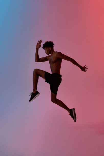 Side view of young sportsman running and jumping - Photo, Image