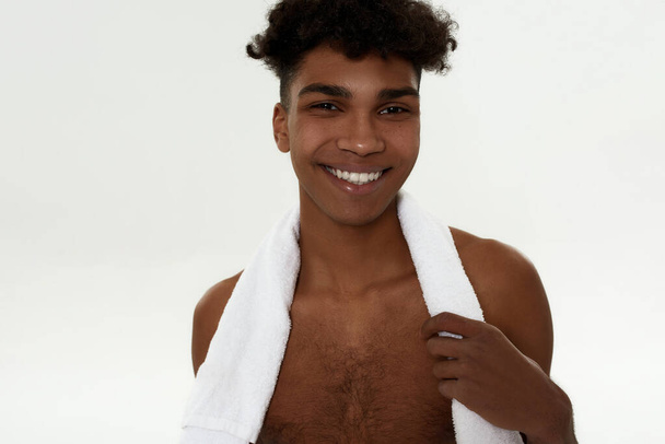 Smiling curly sportsman with towel look at camera - Foto, Imagen