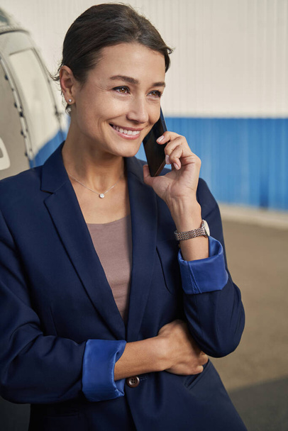 Cheerful elegant entrepreneur talking on cellphone at heliport - Foto, Imagem