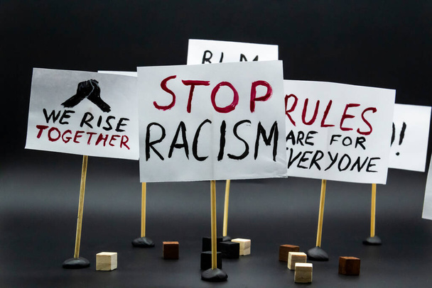 Concept of protest, rally, demonstration. Posters with words "We rise together", Stop racism", Rules are for everyone". - Фото, изображение