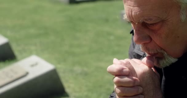 Le vieil homme aux cheveux gris prie sur la tombe du cimetière. Tristesse et tristesse. Religieux homme, 4k 60p Prores - Séquence, vidéo