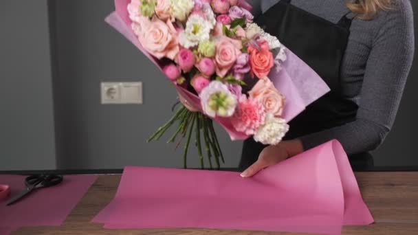 Florista mulher faz elegante buquê de casamento com rosas - Filmagem, Vídeo