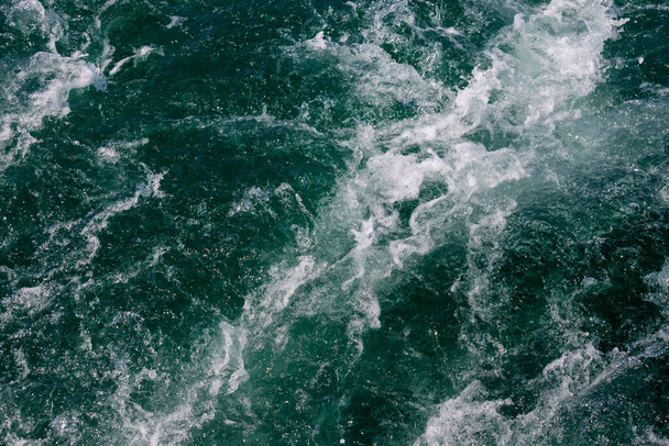 海の波の白い紋章。選択的フォーカス。フィールドの浅い深さ. - 写真・画像