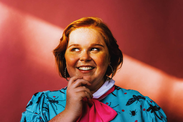 улыбающаяся молодая женщина портрет в студии на розовом фоне - Фото, изображение
